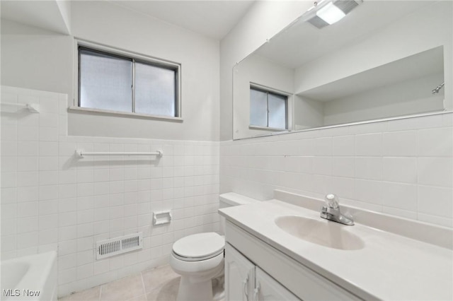 full bath with toilet, vanity, tile patterned flooring, visible vents, and tile walls