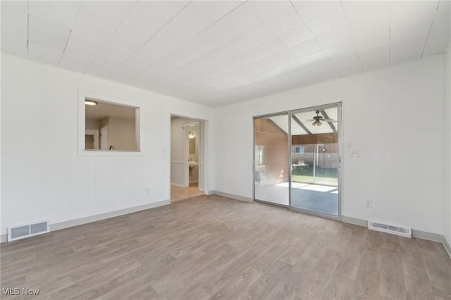 spare room featuring baseboards, visible vents, wood finished floors, and a ceiling fan