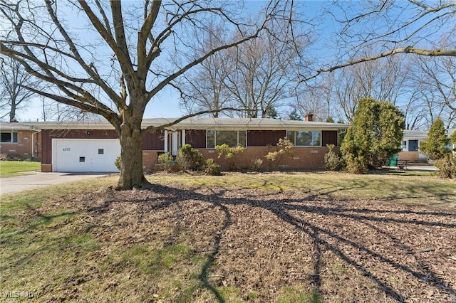 ranch-style house with concrete driveway, a chimney, an attached garage, board and batten siding, and brick siding