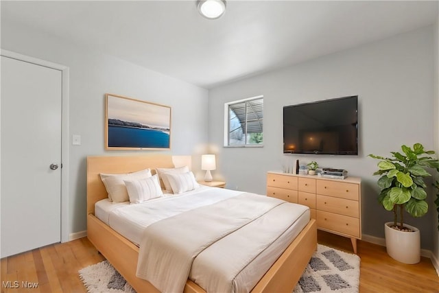 bedroom with baseboards and light wood-style flooring