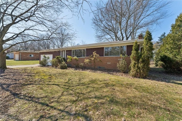 single story home with board and batten siding, a front yard, brick siding, a garage, and a chimney