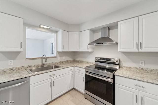 kitchen featuring white cabinets, a sink, stainless steel appliances, and wall chimney exhaust hood