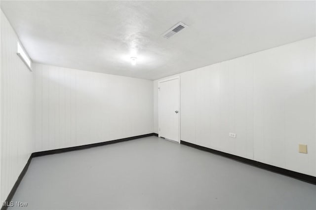 unfurnished room featuring baseboards, finished concrete flooring, and visible vents