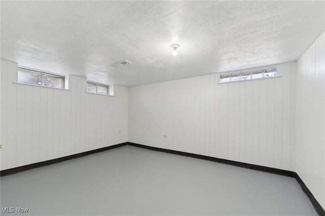 6372 Tanglewood Ln, Seven Hills, OH 44131 - below grade area with baseboards, a textured ceiling, and wood walls