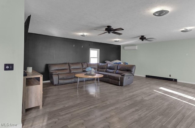 living area with a wall mounted air conditioner, baseboards, wood finished floors, a ceiling fan, and a baseboard heating unit