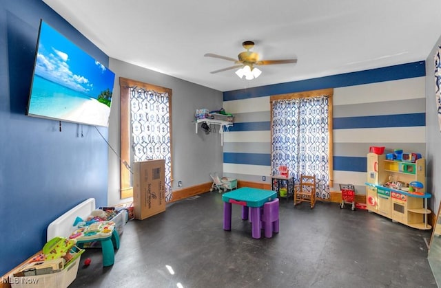 playroom with ceiling fan and concrete flooring