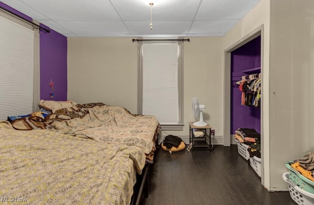 bedroom with dark wood-style floors and a drop ceiling