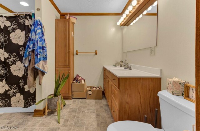 full bathroom featuring vanity, curtained shower, toilet, and crown molding