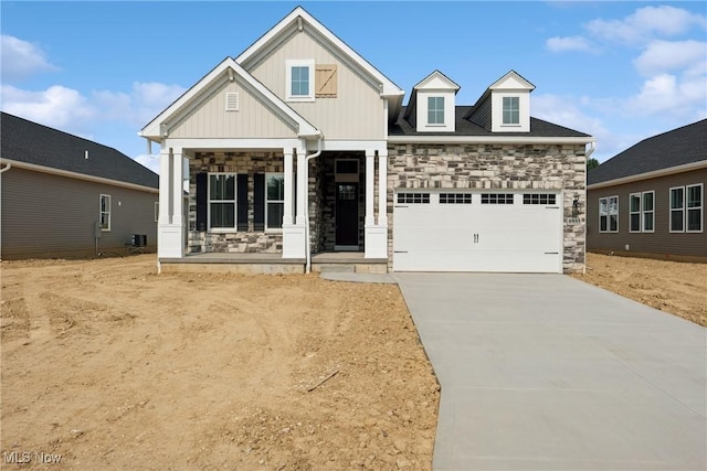 8933 Camden Rd NW, Massillon, OH 44646 - craftsman-style house with stone siding, a garage, concrete driveway, a porch, and board and batten siding