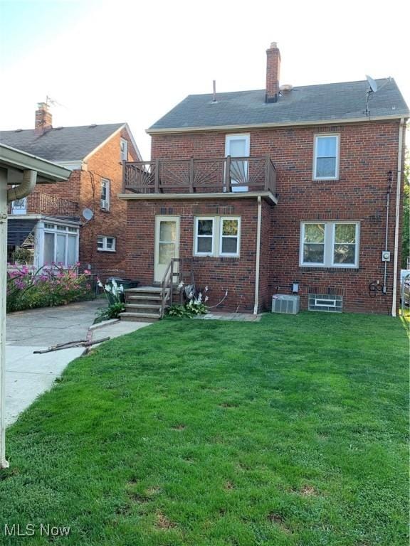 254 E 211th St, Euclid, OH 44123 - back of house with a balcony, a yard, brick siding, a chimney, and cooling unit