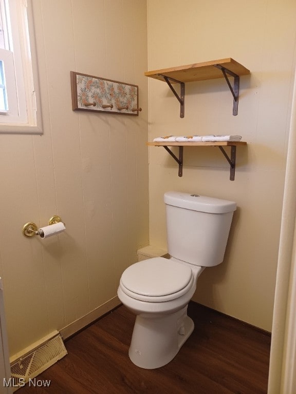 bathroom with visible vents, toilet, and wood finished floors