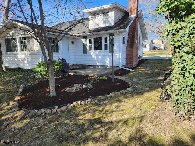 view of front facade featuring a patio and a chimney