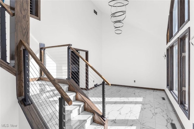 3189 Chardonnay Ln, Poland, OH 44514 - stairway with a high ceiling, marble finish floor, baseboards, and visible vents