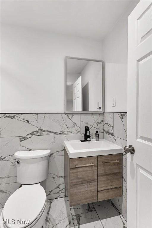 3189 Chardonnay Ln, Poland, OH 44514 - half bath featuring toilet, vanity, marble finish floor, and wainscoting