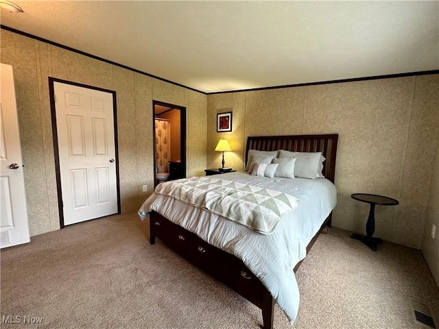 carpeted bedroom with visible vents and crown molding