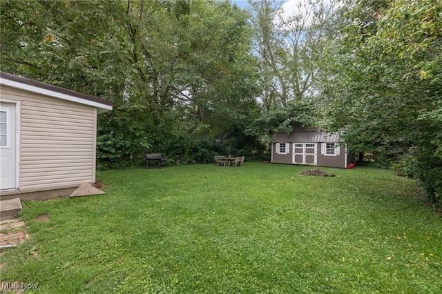 view of yard featuring a storage unit and an outbuilding