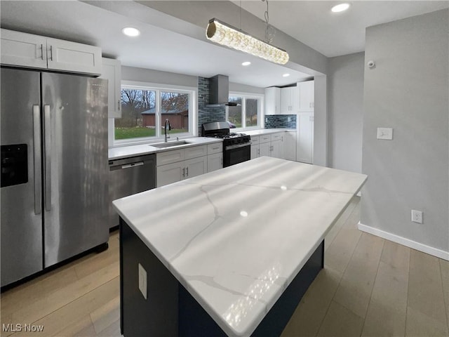 8414 York Rd, North Royalton, OH 44133 - kitchen with white cabinets, stainless steel appliances, a sink, light wood-style floors, and wall chimney range hood
