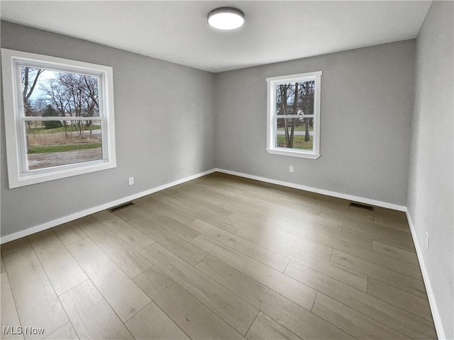 8414 York Rd, North Royalton, OH 44133 - empty room with wood finished floors, a wealth of natural light, baseboards, and visible vents