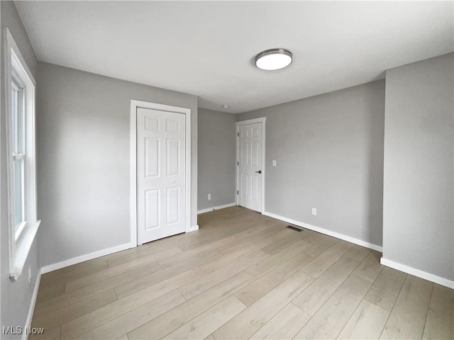8414 York Rd, North Royalton, OH 44133 - unfurnished bedroom featuring baseboards, wood finished floors, visible vents, and a closet