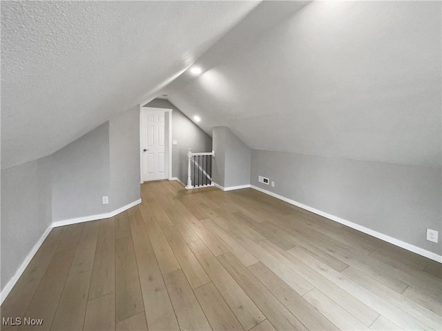 8414 York Rd, North Royalton, OH 44133 - bonus room with wood finished floors, vaulted ceiling, baseboards, and a textured ceiling