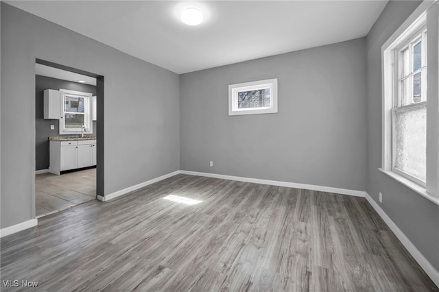 11504 E Blvd, Cleveland, OH 44105 - unfurnished room with baseboards, a sink, and wood finished floors