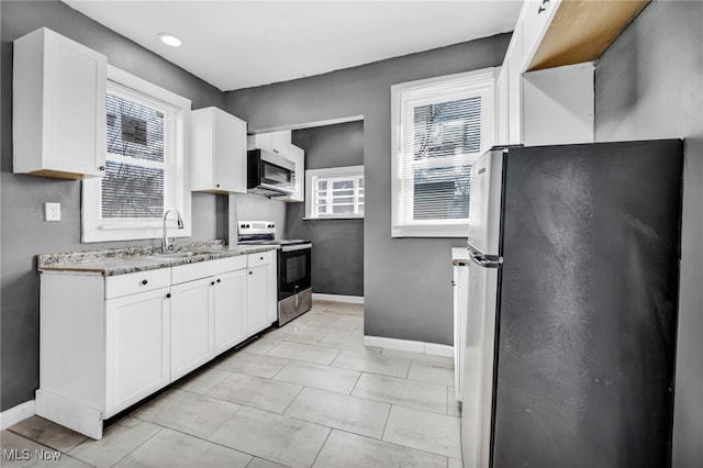 11504 E Blvd, Cleveland, OH 44105 - kitchen featuring baseboards, light stone counters, white cabinetry, appliances with stainless steel finishes, and a sink