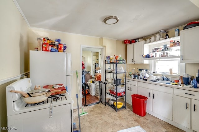 7115 Laverne Ave, Parma, OH 44129 - kitchen featuring light countertops, freestanding refrigerator, washer / dryer, white cabinets, and ornamental molding