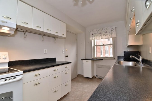 kitchen featuring range hood, dark countertops, white cabinetry, a sink, and white range with electric stovetop