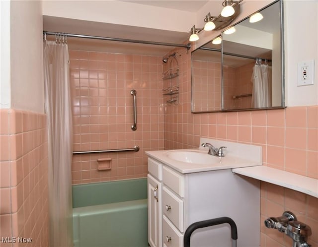 full bath featuring tile walls, shower / tub combo, and vanity