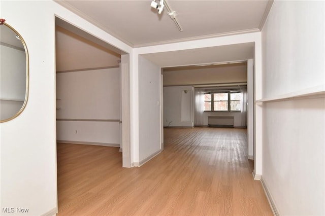 corridor with baseboards, ornamental molding, and wood finished floors