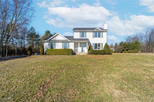 view of front of home with a chimney and a front yard
