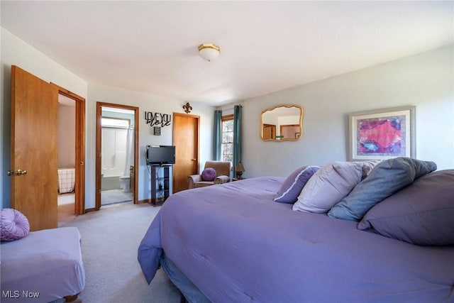 carpeted bedroom featuring baseboards and ensuite bath