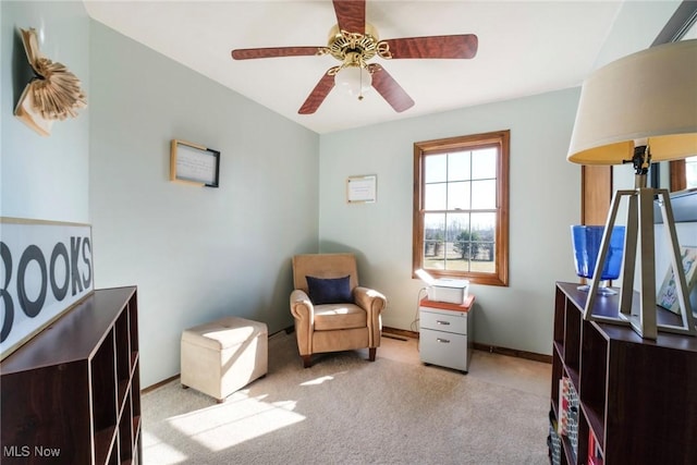 living area featuring baseboards, carpet floors, and ceiling fan
