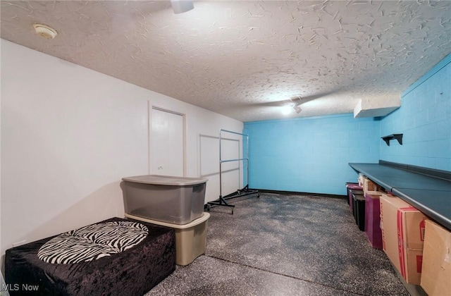 interior space featuring concrete block wall and a textured ceiling
