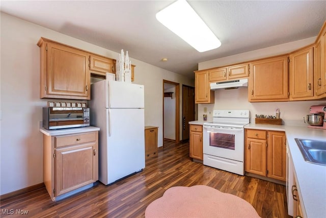 kitchen featuring dark wood-style flooring, light countertops, white appliances, under cabinet range hood, and a sink