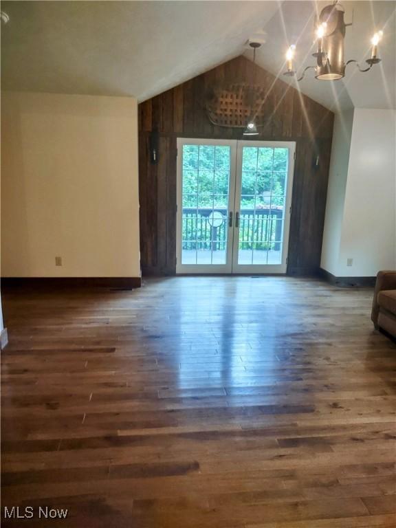 6846 Wakefield, Hiram, OH 44234 - unfurnished living room with wood finished floors, lofted ceiling, baseboards, a chandelier, and wood walls