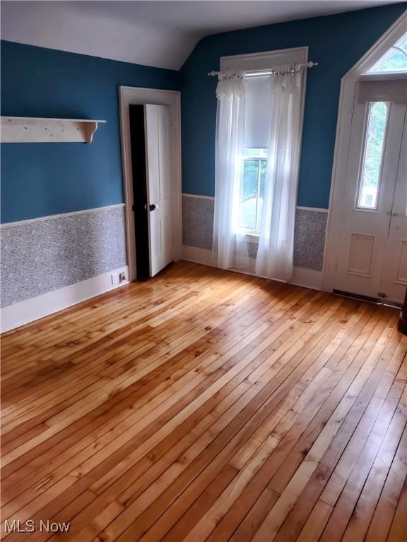 6846 Wakefield, Hiram, OH 44234 - spare room featuring wood-type flooring, a wainscoted wall, and vaulted ceiling