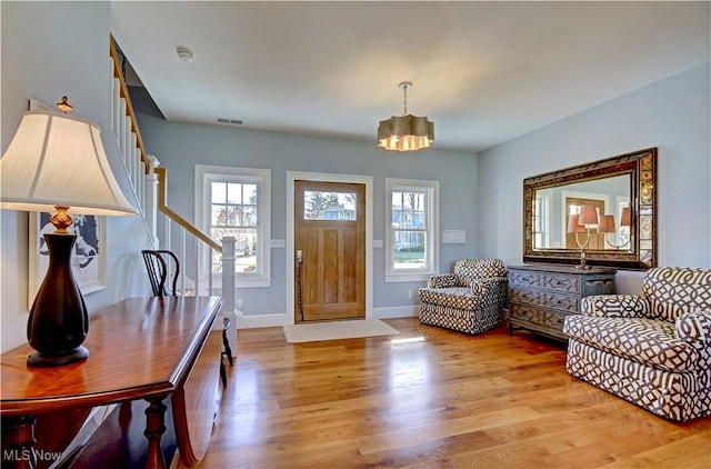 entrance foyer with a healthy amount of sunlight, light wood-style floors, and visible vents