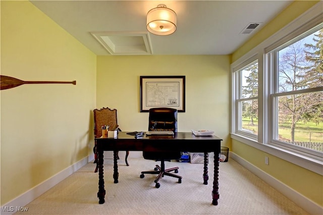 carpeted office with baseboards, visible vents, and attic access