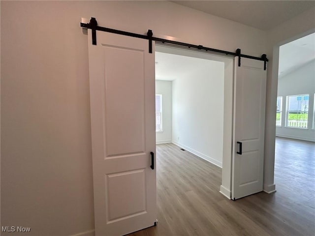 8929 Camden Rd NW, Massillon, OH 44646 - hallway featuring a barn door, dark wood-style flooring, and baseboards