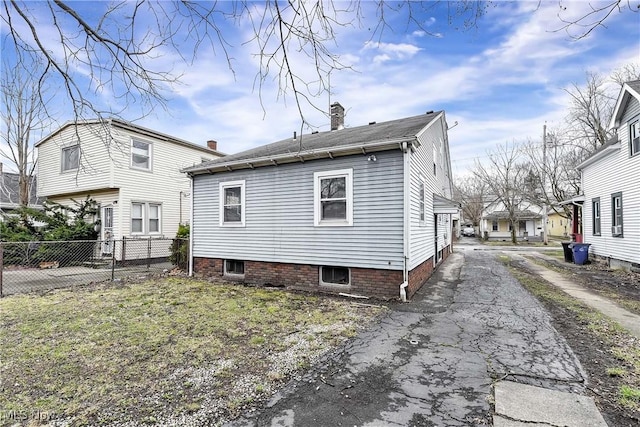 3716 E 52nd St, Cleveland, OH 44105 - rear view of property featuring driveway, fence, and a chimney