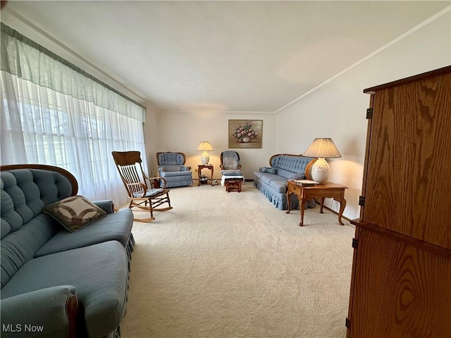 carpeted living room with ornamental molding and vaulted ceiling