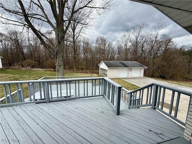 wooden terrace featuring an outbuilding, a detached garage, and a yard
