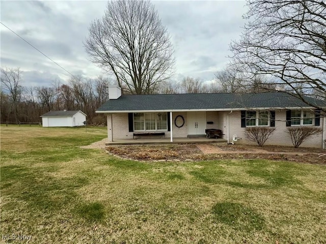 ranch-style home with an outbuilding, a front yard, brick siding, a shingled roof, and a chimney