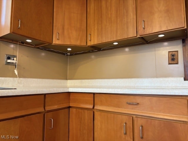 kitchen with light countertops and brown cabinetry