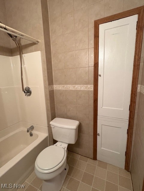 bathroom featuring tile walls, bathtub / shower combination, toilet, and tile patterned floors