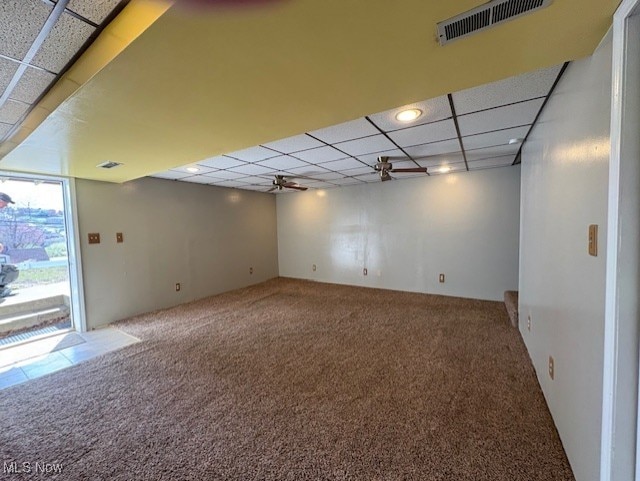 below grade area featuring a paneled ceiling, carpet floors, and visible vents