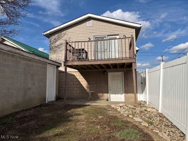 rear view of property with a deck and fence