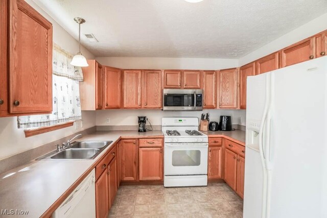 2500 Marlborough Dr, Uniontown, OH 44685 - kitchen with light countertops, visible vents, white appliances, a sink, and pendant lighting