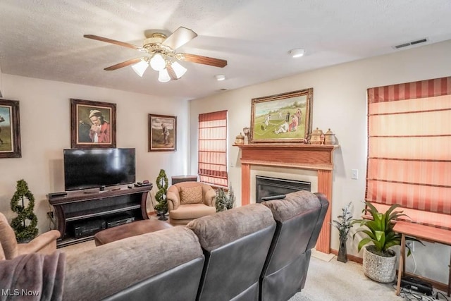 2500 Marlborough Dr, Uniontown, OH 44685 - living room featuring light colored carpet, a textured ceiling, ceiling fan, visible vents, and a glass covered fireplace